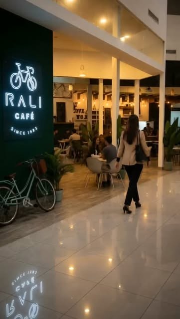 La entrada de Rali Café con su bicicleta y el logo iluminado
